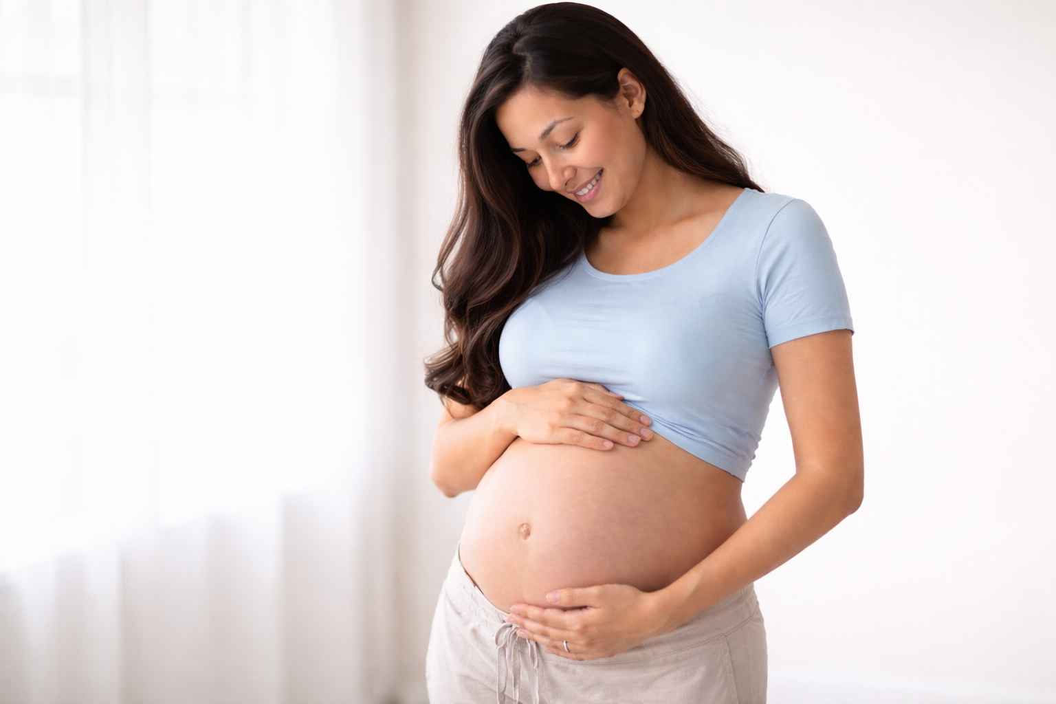 Pregnant woman holding her belly.