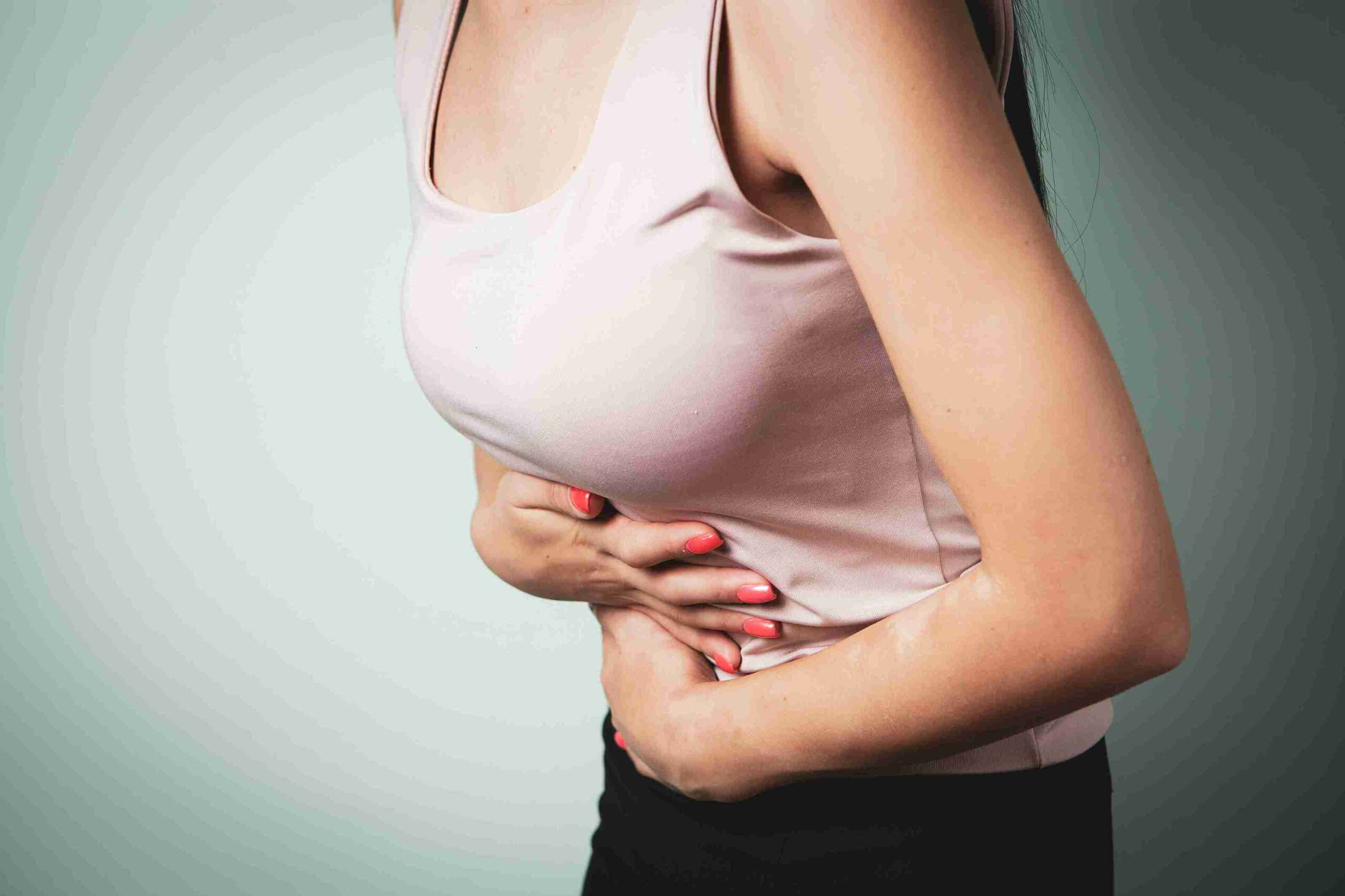 Woman holding lower abdomen, showing pelvic pain associated with endometriosis.